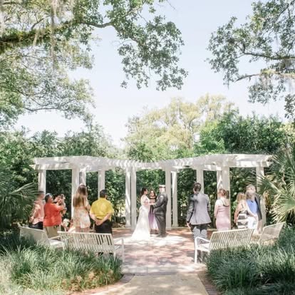 Wedding ceremony beneath a garden arbor