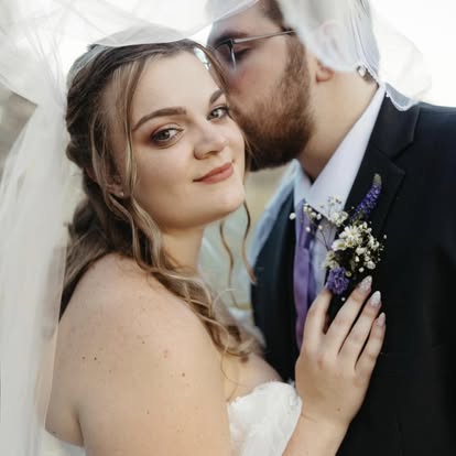 A groom kissing his bride on the cheek