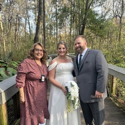 Esther with newlyweds on a wooded footbridge