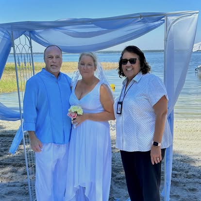 Esther with a couple at a beach ceremony