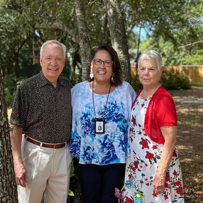 Esther with a couple in a wooded garden