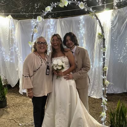 Wedding party beneath a white draped arbor