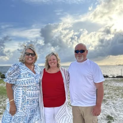 Esther with a couple at their beach wedding