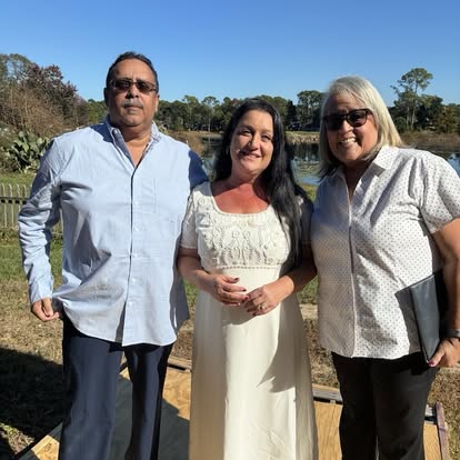 Esther with a couple under a clear blue sky