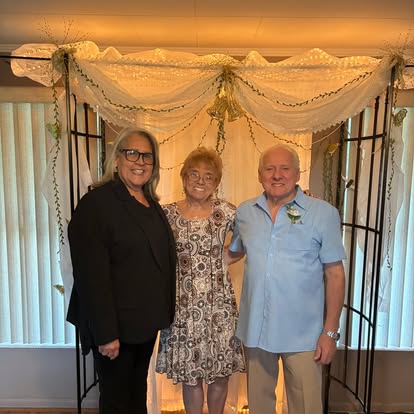 Esther with a couple in front of a decorated doorway
