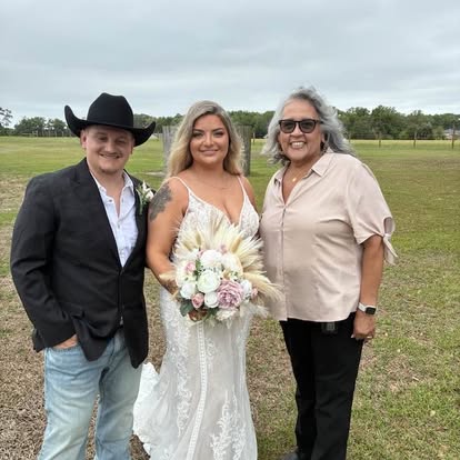 Esther with newlyweds in a grassy field