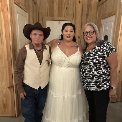 Esther with newlyweds during an indoor celebration